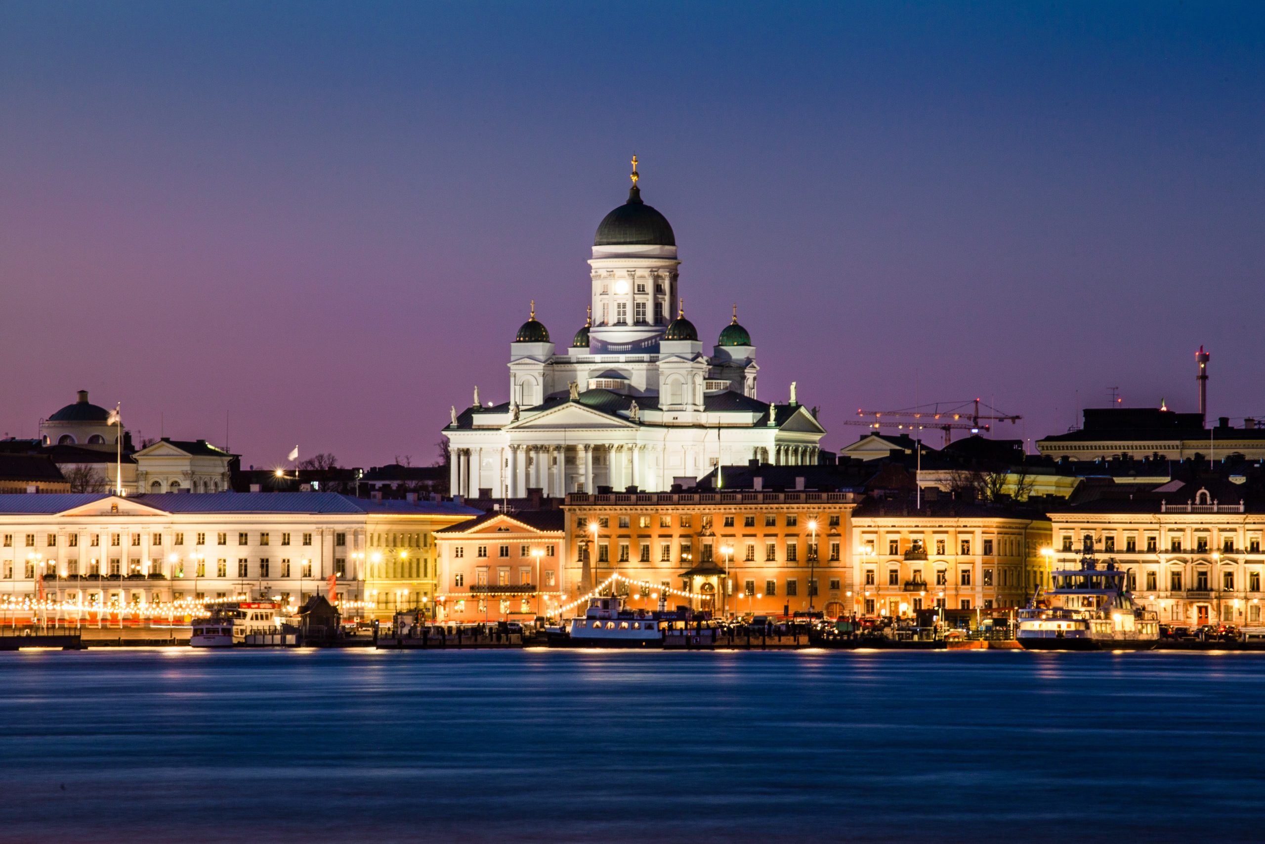 A church and buildings are lit up at night in Helsinki.